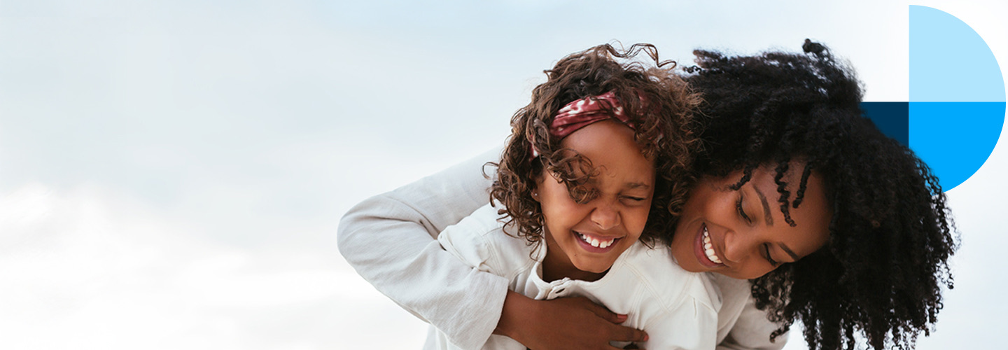 A parent and child smiling together outdoors